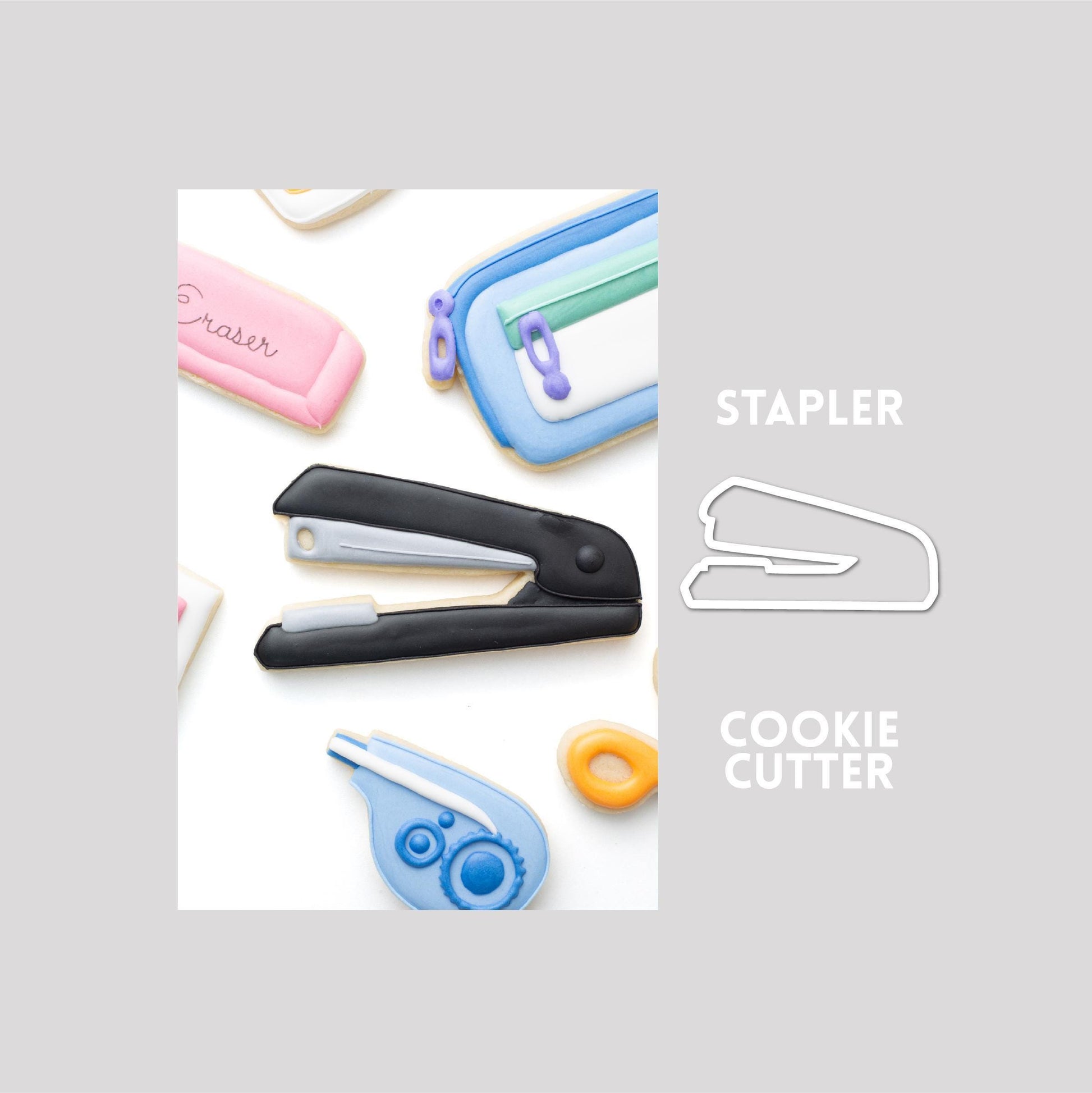 Decorated stapler sugar cookie next to a stapler cookie cutter outline on a gray background.