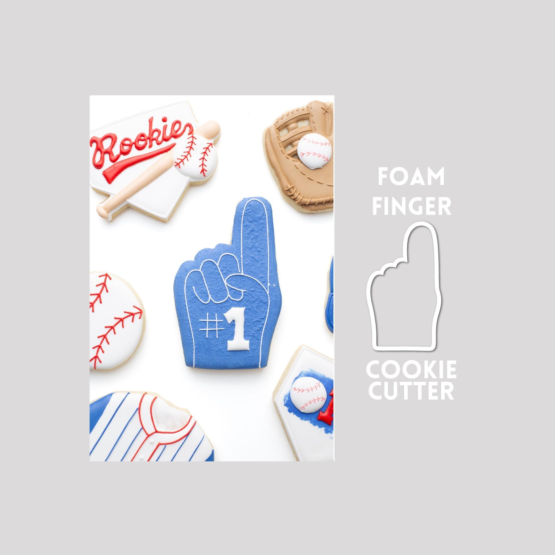 Decorated foam finger sugar cookie next to a foam finger cookie cutter outline on a gray background.