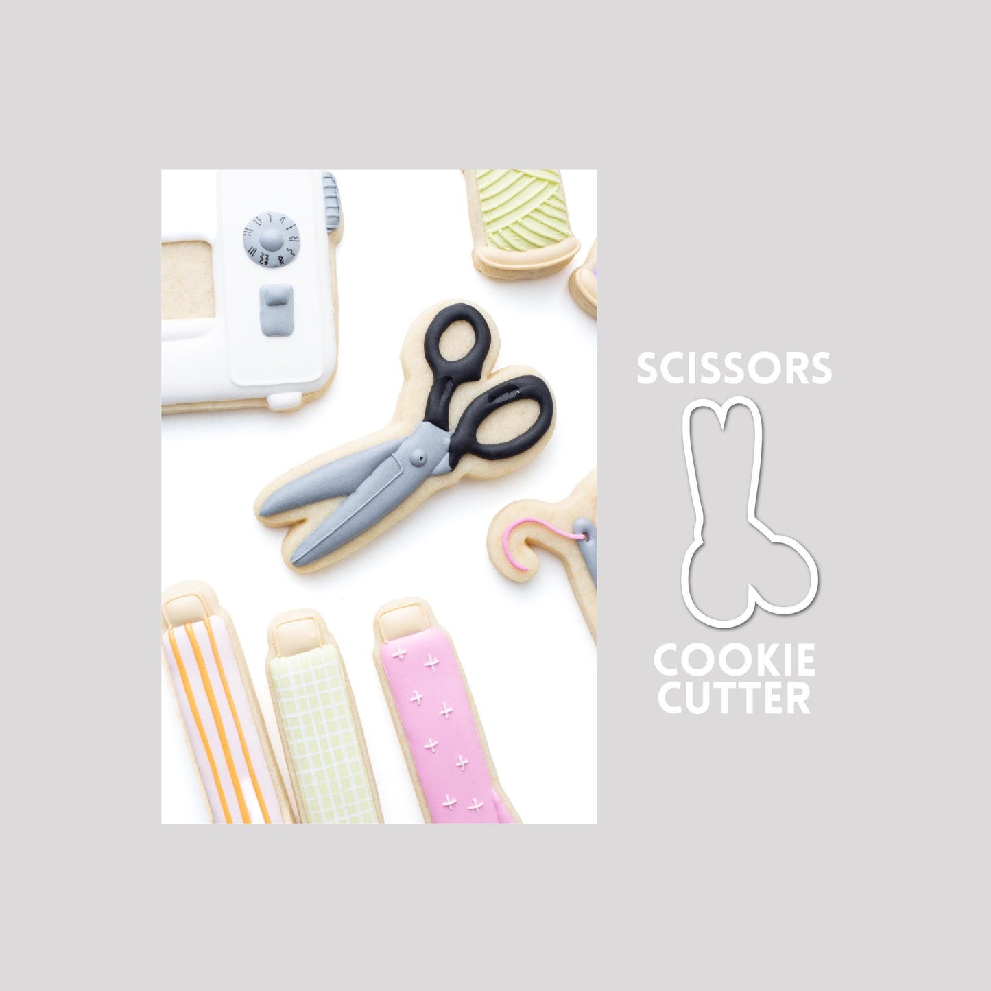 Decorated scissors sugar cookie next to a scissors cookie cutter outline on a gray background.