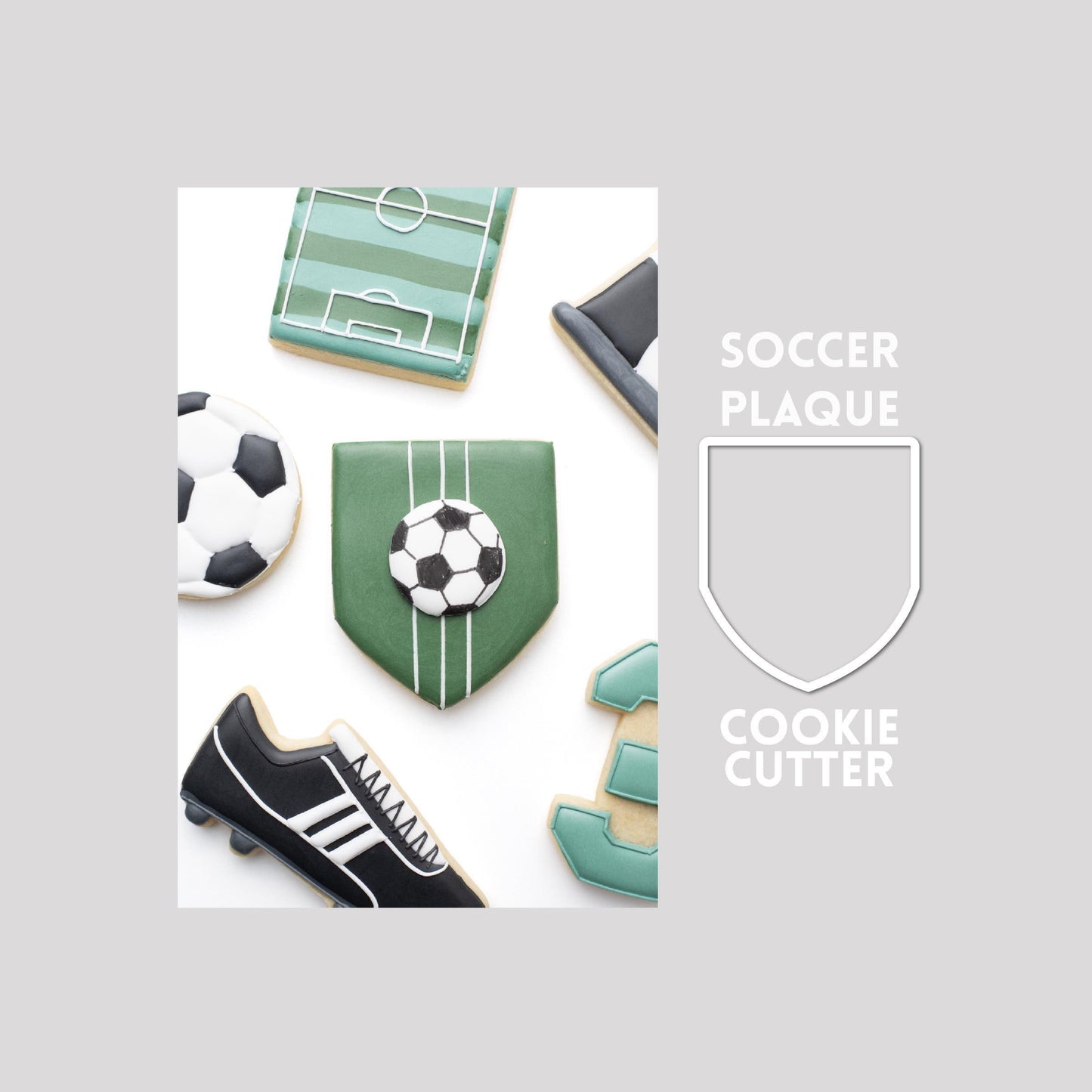 Decorated soccer plaque sugar cookie next to a soccer plaque cookie cutter outline on a gray background.