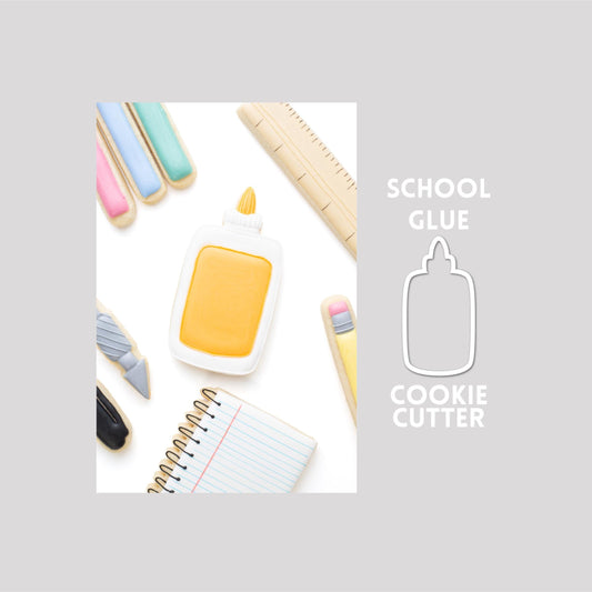 Decorated school glue sugar cookie next to a school glue cookie cutter outline on a gray background.