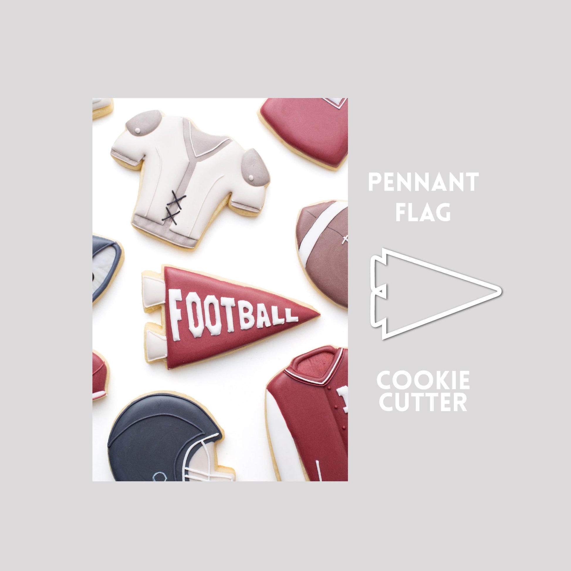 Decorated pennant flag sugar cookie next to a pennant flag cookie cutter outline on a gray background.