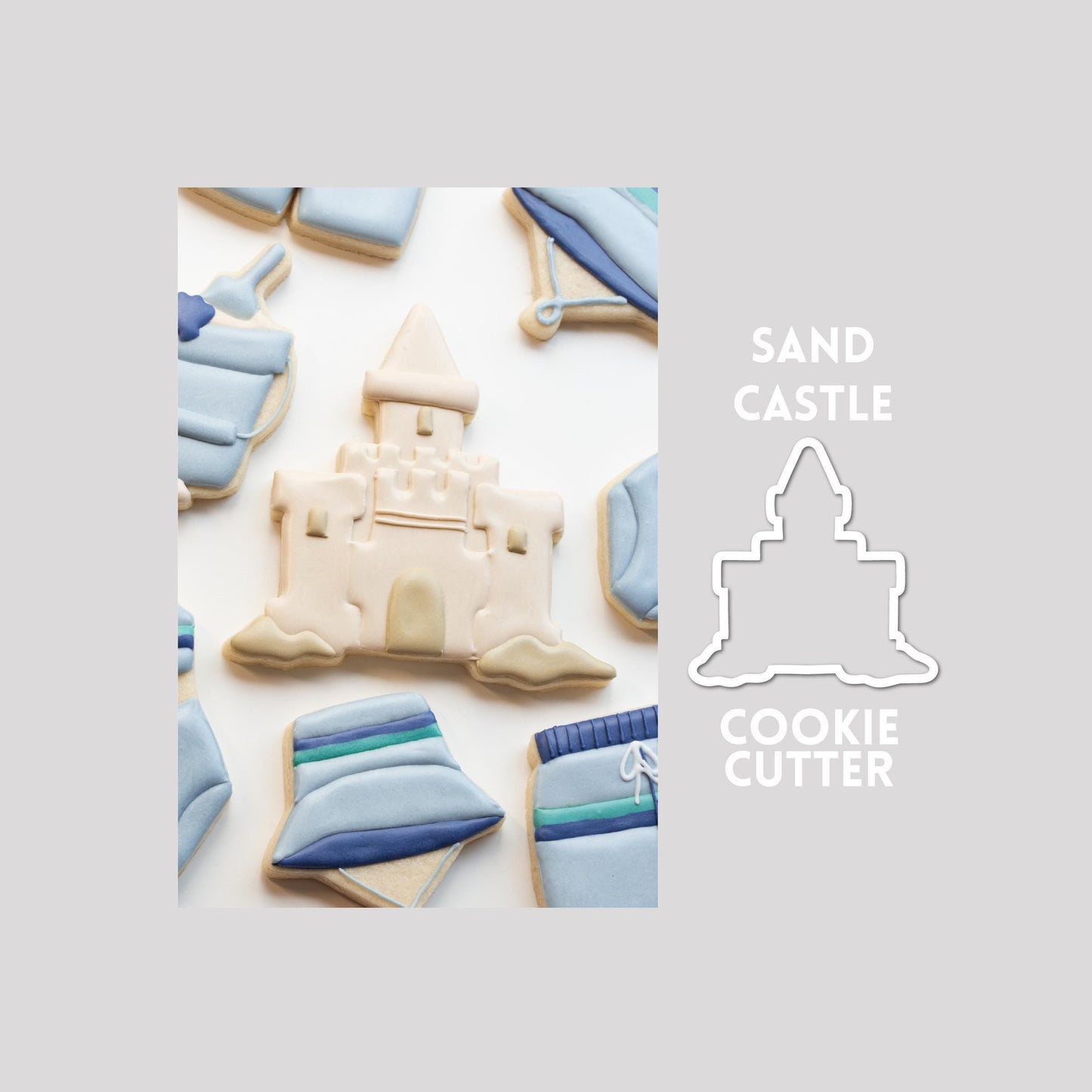 Decorated sand castle sugar cookie next to a sand castle cookie cutter outline on a gray background.