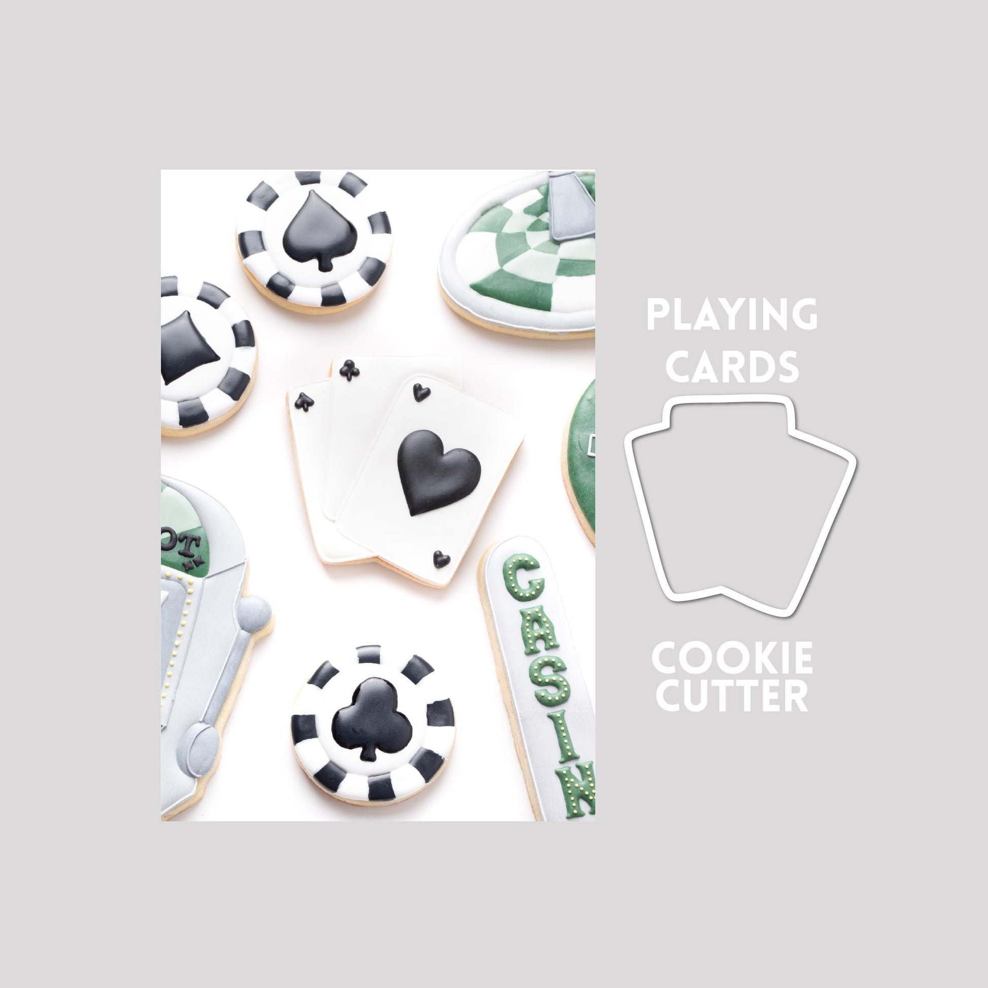 Decorated playing cards sugar cookie next to a playing cards cookie cutter outline on a gray background.