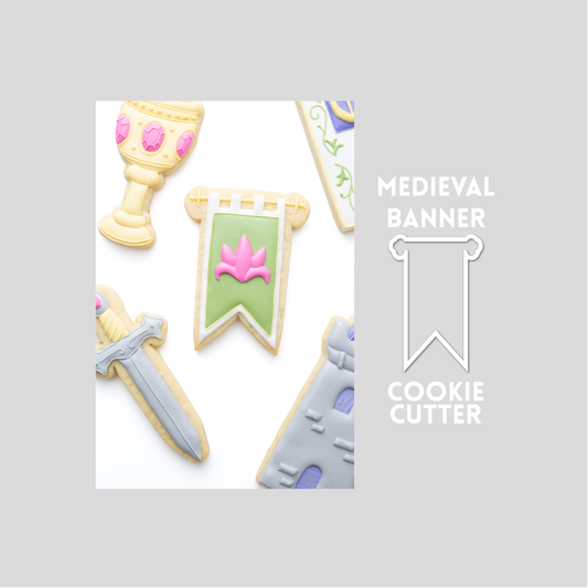 Decorated medieval banner sugar cookie next to a medieval banner cookie cutter outline on a gray background.